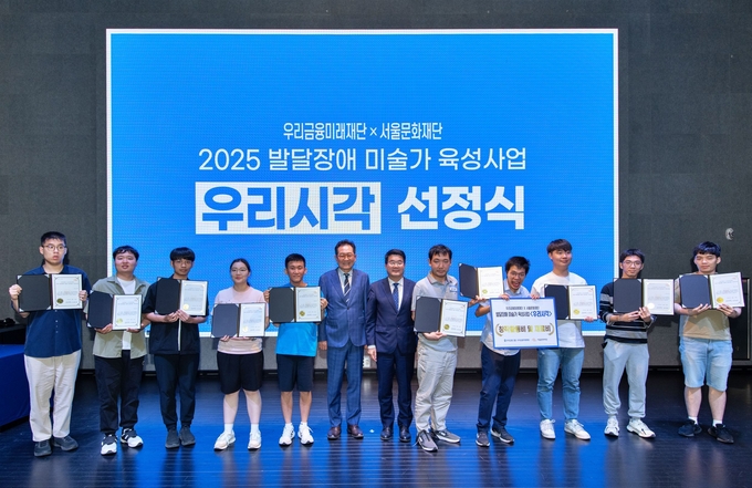 장광익 우리금융미래재단 사무국장(왼쪽 6번째), 송형종 서울문화재단 대표이사(왼쪽 7번째)가 발달장애 미술가 육성사업 ‘우리시각’ 선정작가 10인과 기념촬영을 하고 있다. (사진=우리금융미래재단 제공)