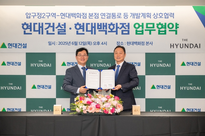(왼쪽부터) 이인기 현대건설 주택사업본부장과 김창섭 현대백화점 영업본부장이 협약식을 마치고 기념촬영을 하고 있다. (사진=현대건설 제공)