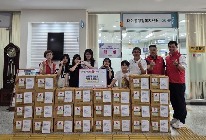 군포대야초 학생들이 알뜰시장 수익금으로 마련한 라면 28박스를 대야동 지역사회보장협의체에 기탁하고 있다. (사진=군포시 제공)