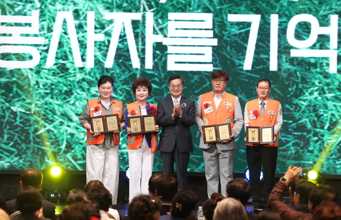17일 오후 화성시 SINTEX에서 열린 2025년 경기도 자원봉사대회에서 김동연 경기도지사가 우수 자원봉사자 인증패를 수여하고 기념촬영을 하고 있다. (사진=경기도 제공)