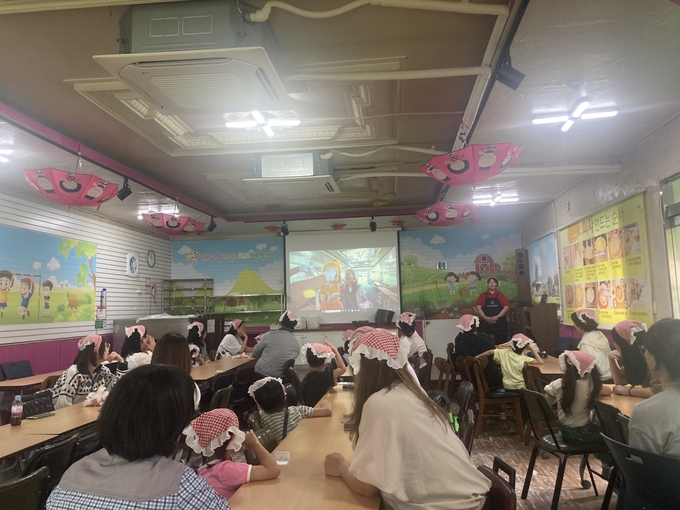 고양낙농치즈체험장에서 진행된 피자 만들기 사전 교육 모습. 참여 아동과 보호자들이 강사의 설명을 집중해 듣고 있다. (사진=군포시 제공)