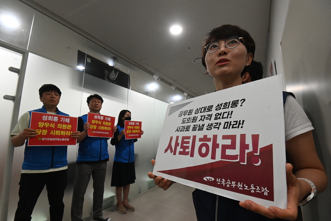 경기도청 공무원노동조합과 전국공무원노동조합 경기지역본부 경기도청지부 관계자들이 18일 오전 경기도의회 운영위원회 회의실 앞에서 양우식(국힘·비례) 경기도의원의 사퇴를 촉구하는 내용의 피켓을 들고 있다. (사진=옥지훈 기자)