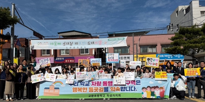 교문초등학교 학생들과 학부모들이 정문앞 등굣길 차량통행금지 해제를 반대하며 시위를 하고 있다. (사진=구리남양주교육지원청 제공)