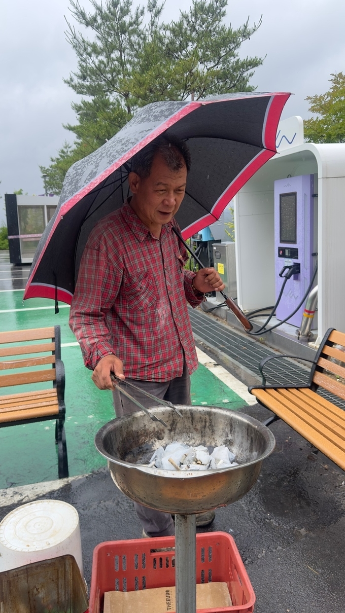 이치균 본부장이 지난 20일 장맛비가 내리고 있는데도 우산을 들고 실습실 공사현장과 교정을 돌며 버려진 쓰레기를 줍고 있었다.(사진=대경대학교 제공)