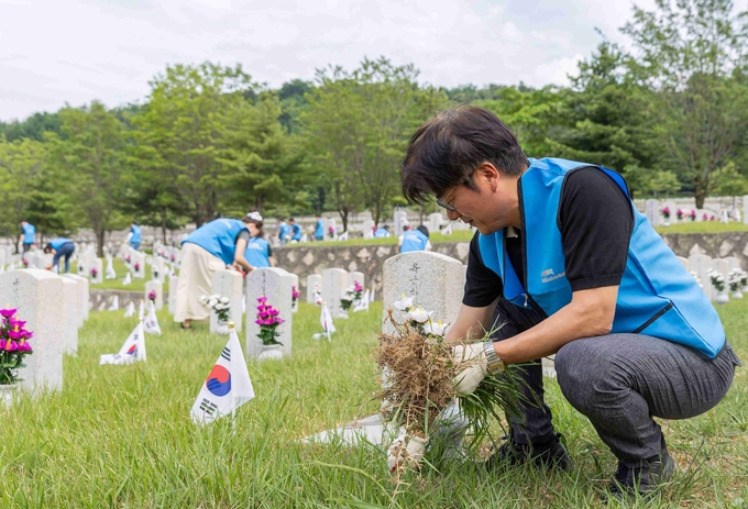정종철 CFS 대표이사가 19일 국립서울현충원에서 직원들과 함께 묘역 정화 봉사활동을 하고 있다. (사진=쿠팡 제공)