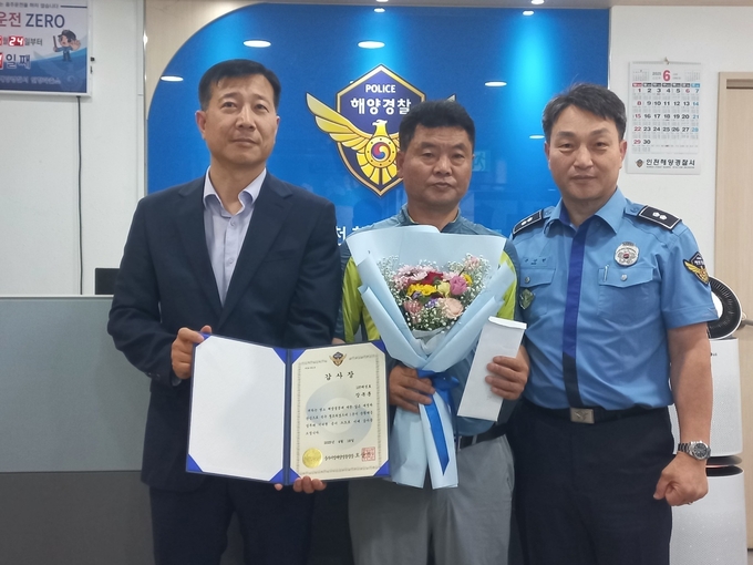 고무보트 밀입국 기도자를 신고한 107태성호 장복훈 선장(가운데)이 인천해경으로부터 감사장을 받고 기념촬영을 하고 있다. ( 사진 = 인천해양경찰서 제공 )