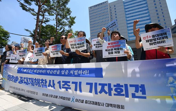 32명의 사상자를 낸 아리셀 참사 1주기를 하루 앞둔 23일 수원시 수원지방법원 청사 앞에서 열린 '아리셀 중대재해참사 1주기 기자회견'에서 참석자들이 구호를 외치고 있다.