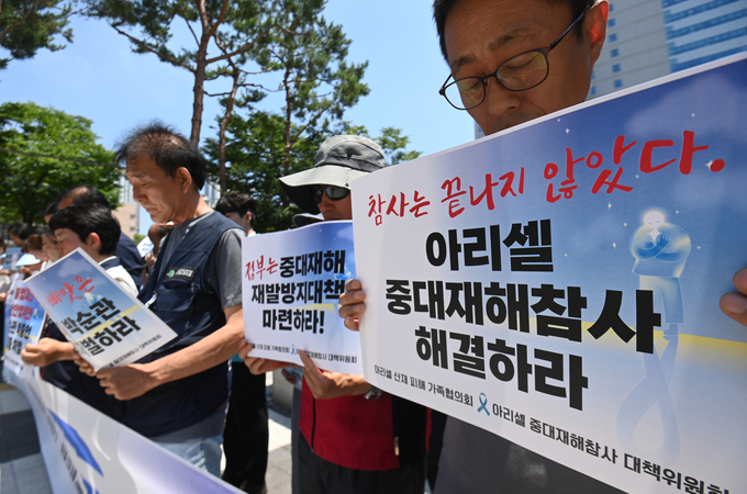 32명의 사상자를 낸 아리셀 참사 1주기를 하루 앞둔 23일 수원시 수원지방법원 청사 앞에서 열린 '아리셀 중대재해참사 1주기 기자회견'에서 참석자들이 묵념을 올리고 있다.