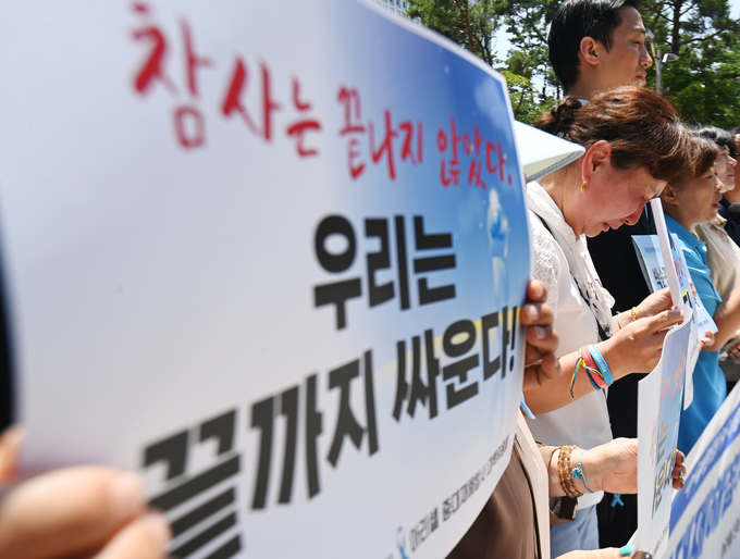 32명의 사상자를 낸 아리셀 참사 1주기를 하루 앞둔 23일 수원시 수원지방법원 청사 앞에서 열린 '아리셀 중대재해참사 1주기 기자회견'에서 한 유가족이 고개를 떨구며 흐느끼고 있다.