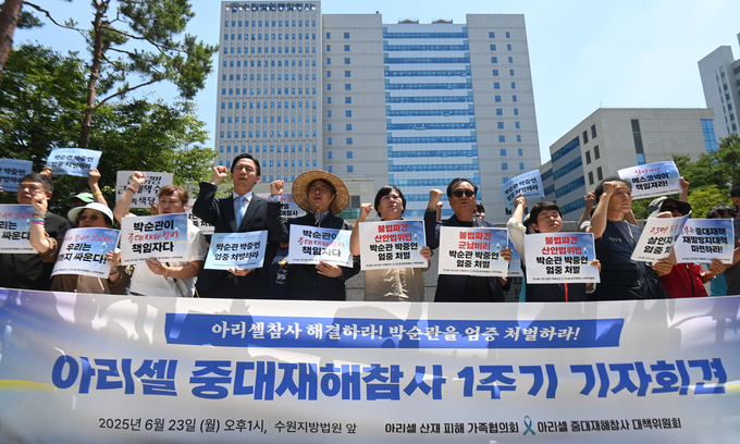 32명의 사상자를 낸 아리셀 참사 1주기를 하루 앞둔 23일 수원시 수원지방법원 청사 앞에서 열린 '아리셀 중대재해참사 1주기 기자회견'에서 참석자들이 구호를 외치고 있다.