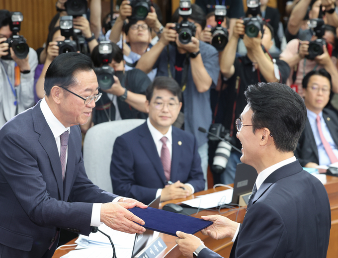 김민석 국무총리 후보자가 지난 24일 국회에서 열린 인사청문회에서 총리 후보자 인사청문특별위원회 위원장인 이종배 국민의힘 의원에게 선서문을 제출하고 있다. 가운데는 국민의힘 간사인 배준영 의원. (사진=연합뉴스)