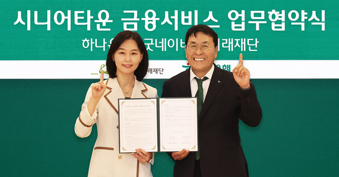 양진옥 굿네이버스 미래재단 대표(왼쪽)와 김진우 하나은행 중앙영업그룹 부행장이 업무협약서를 들고 기념 촬영을 하고 있다. (사진=하나은행 제공)