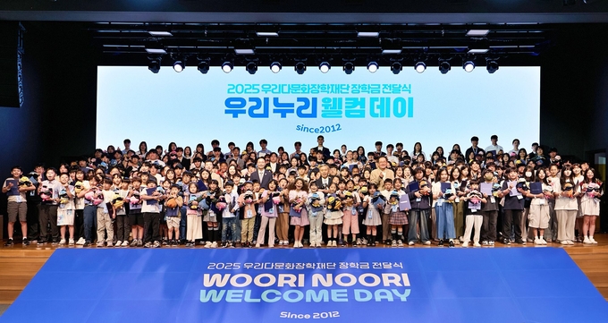 김중곤 굿네이버스 사무총장(왼쪽), 이종휘 우리다문화장학재단 이사장(가운데), 장광익 우리다문화장학재단 사무국장(오른쪽)이 장학생들과 기념촬영을 하고 있다. (사진=우리금융그룹 제공)