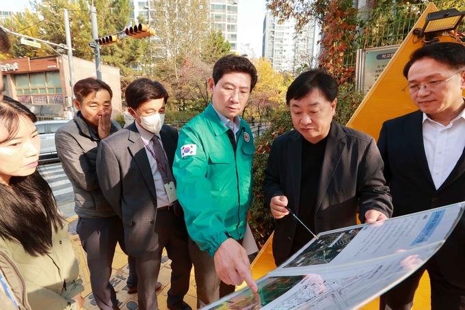 이상일 용인특례시장이 상현초등학교를 방문해 협소한 정문 앞 대기 장소 개선 방안을 관계자들의 논의하고 있는 모습. (사진=용인시 제공)