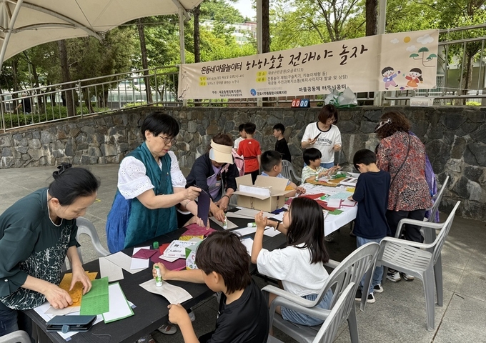 군포시 재궁근린공원에서 열린 ‘온동네 마을놀이터’에서 아이들이 어르신들과 함께 전래 공예 체험을 즐기고 있다. (사진=군포시 제공)