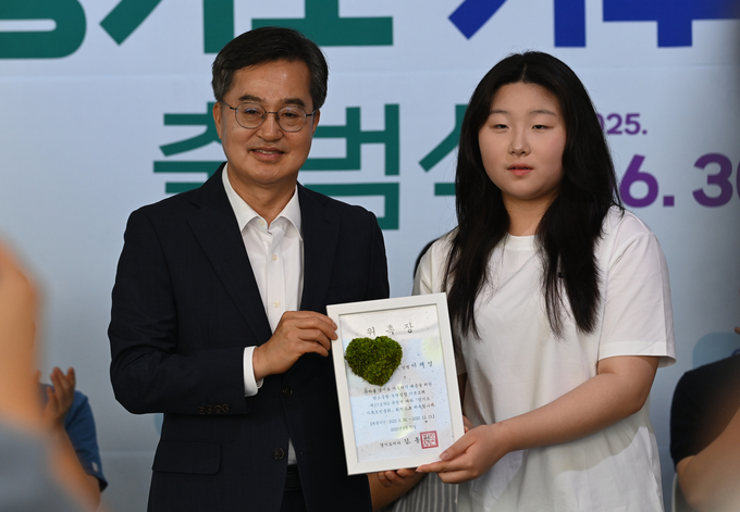 김동연 경기도지사가 30일 오전 시흥시 시흥에코센터에서 열린 경기도 기후도민총회 출범식에서 한 학생에게 기후도민 위촉장을 전달하고 있다.