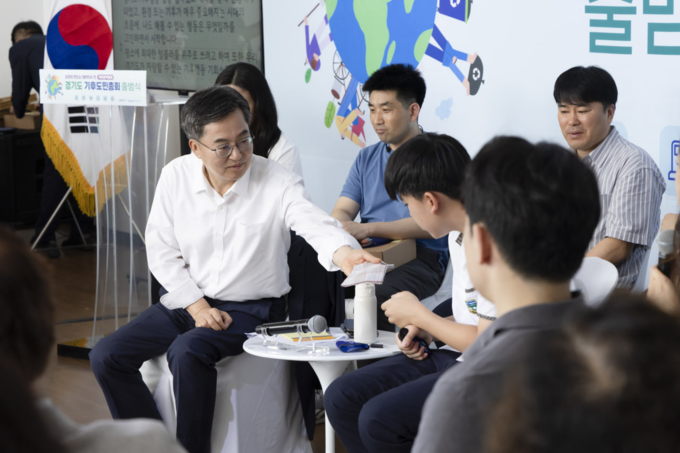 30일 시흥에코센터에서 진행된 ‘경기도 도민기후총회’에 참석한 김동연 경기도지사가 학생 참가자에게 땀을 닦으라며 자신의 손수건을 건네고 있다. (사진=경기도 제공)