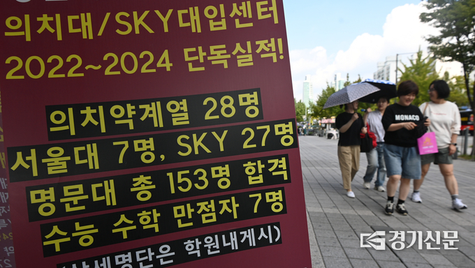 지난해 안양시 동안구 학원가에서 학부모와 자녀들이 전년도 입시 결과 홍보문구가 붙어 있는 학원 앞을 지나치고 있다. (사진=옥지훈 기자)