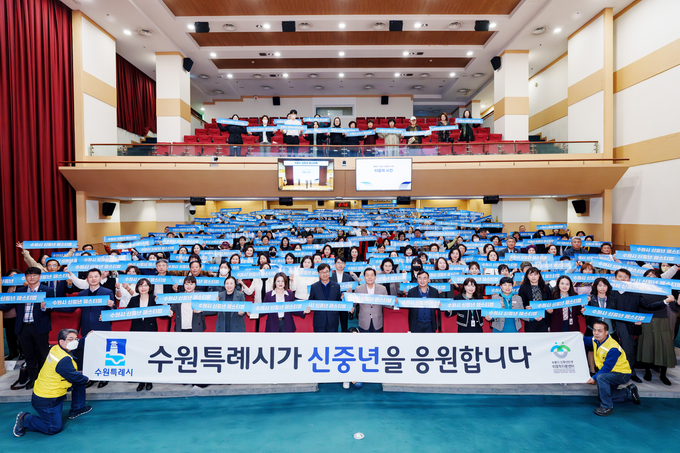 지난 2023년 수원시신중년센터 성과보고회 참석자들이 함께 손팻말을 들고 있다. (사진=수원시 제공)
