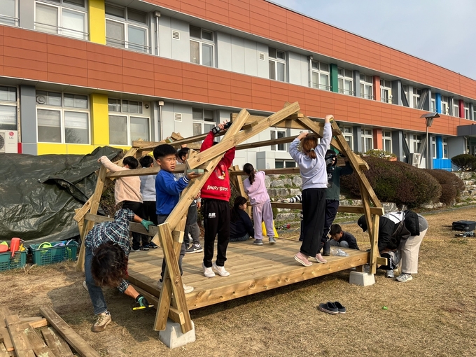 안성 죽화초등학교 학생들이 숲놀이터에 필요한 놀이기구를 직접 만들고 있다. (사진=죽화초등학교 제공)