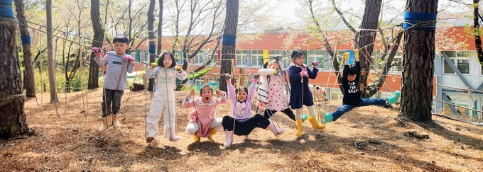 죽화초등학교 학생들이 숲놀이터에서 뛰어놀고 있다. (사진=죽화초등학교 제공)