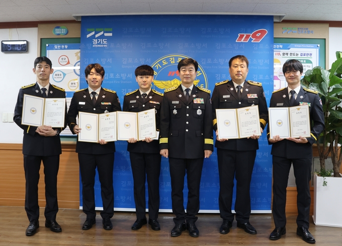 김포소방서 직원들의 이달의 모범 소방공문원 선정 표창을 받고 유해공 서장과 기념사진을 찍고 있다. (사진=김포소방서 제공)