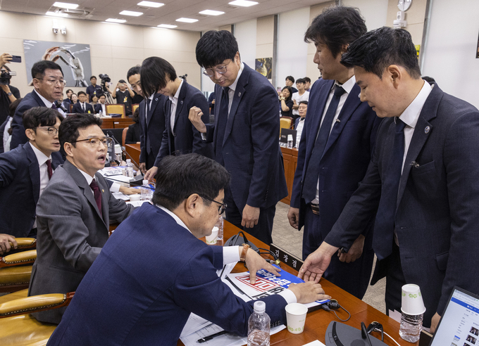 14일 국회 과학기술정보방송통신위에서 열린 배경훈 과학기술정보통신부 장관 후보자 인사청문회에서 국회 경위들이 최민희 위원장의 요청에 따라 국민의힘 과방위원들이 노트북 앞에 붙인 인쇄물을 제거하기 위해 야당 의원석 앞에 서 있다. 이날 배 장관 후보자 청문회는 국민의힘 의원들이 국회에서 처리된 방송3법에 항의하는 인쇄물을 노트북에 붙이는 것을 두고 여야 갈등이 계속되면서 오전 청문 진행을 하지 못한 채 정회됐다. (사진=연합뉴스)