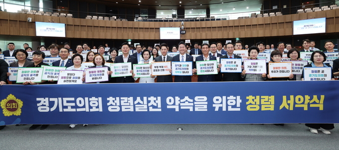 김진경 경기도의회 의장 등 경기도의원들이 15일 경기도의회 본회의장에서 열린 청렴 서약식에서 청렴 슬로건이 적힌 피켓을 들고 기념촬영을 하고 있다. (사진=경기도의회 제공)