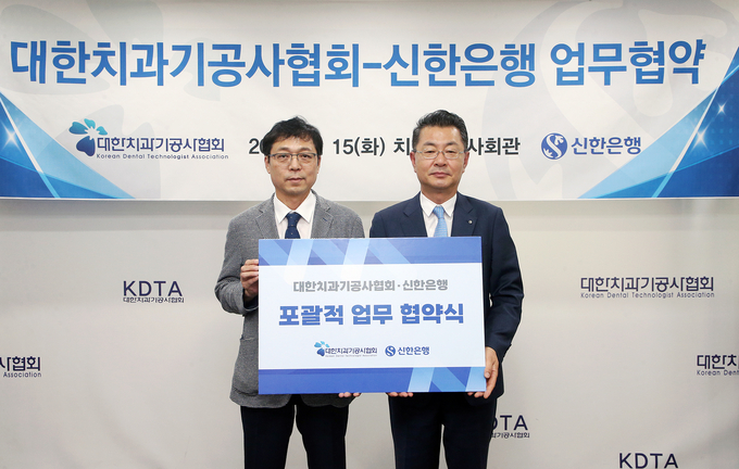 김재민 신한은행 영업추진1그룹장(오른쪽)과 김정민 대한치과기공사협회장이 업무협약식에서 기념촬영을 하고 있다. (사진=신한은행 제공)