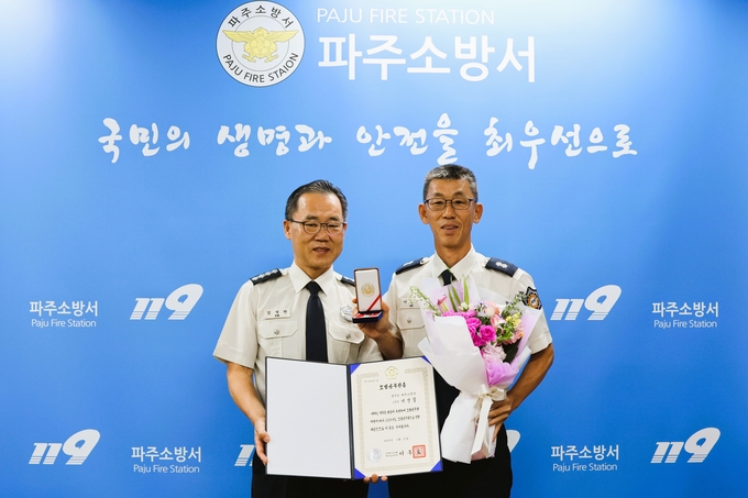 2025년 상반기 모범공무원에 선정돼 국무총리 표창을 수상한 파주소방서 이건칠 소방경(사진 오른쪽)이 김명찬 소방서장과 기념촬영을 하고 있다. (사진=파주소방서 제공)<br>
