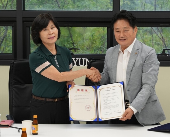 김순원 평택항창고물류협동조합장과 김경배 한국화명유한회사 대표가 업무협약을 체결한 후 서로 손을 맞잡고 기념 촬영 중이다.(사진=평택항창고물류협동조합 제공)