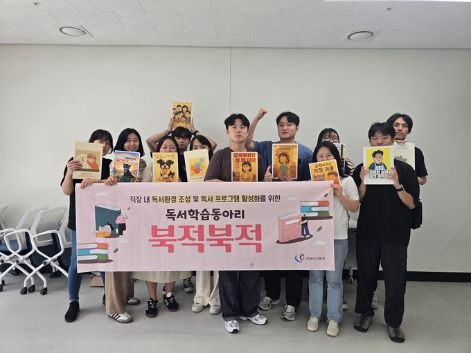 군포도시공사 독서 학습동아리 ‘북적북적’ 참여 직원들이 생성형 AI를 활용해 제작한 그림책을 들고 기념촬영을 하고 있다. (사진=군포도시공사 제공)