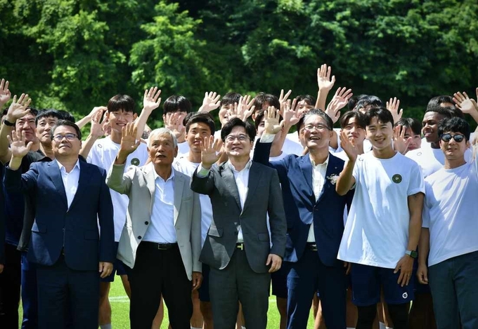 마산동 솔터축구장 보조구장 개장식에 김병수 시장과 임청수 김포시 체육회 회장, 고정운 김포FC 감독 등 관계자들이 손을 흔들어 보이고 있다.( 사진=김포시청 제공)