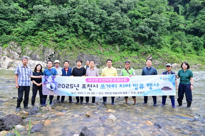 백영현 포천시장(중앙 노란상의)과 어업관계자들이 쏘가리 치어를 방류한 후 기념사진을 촬영했다. (사진=포천시 제공)