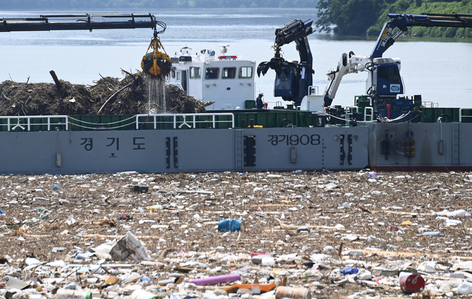 23일 남양주시 한강 상류 팔당호에서 경기도수자원본부 관계자들이 수도권 지역에 내린 폭우로 유입된 쓰레기를 수거하고 있다.
