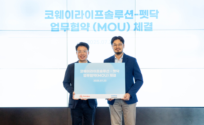 지난 23일 서울 구로구 지타워 코웨이라이프솔루션 본사에서 열린 협약식에서 김명곤 코웨이라이프솔루션 대표이사(왼쪽)와 오태환 펫닥 대표이사가 기념 촬영을 하고 있다. (사진=코웨이 제공)