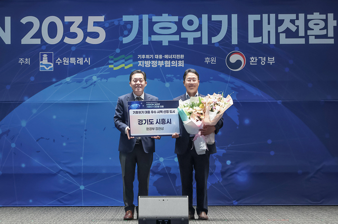  수원컨벤션센터에서 지난 24일 열린 '기후위기 대전환’ 포럼 본행사에서 시흥시가 환경부장관상을 받아 양순필 시흥시 환경국장(오른쪽)이 지방정부협의회 회장도시인 이재준 수원시장(왼쪽)과 기념촬영을 하고 있다. (사진=시흥시 제공)