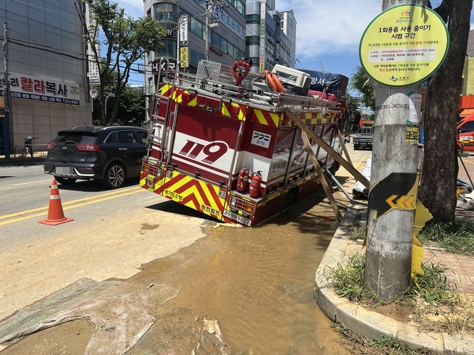 지난 26일 수원시 영통구 원천동 일대 한 도로에서 지반 침하가 발생해 소방차의 뒷바퀴가 빠져있다. (사진=장진 기자)