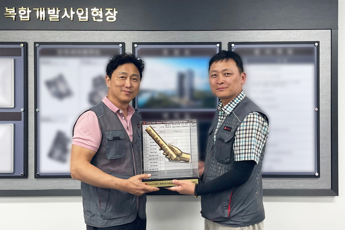 이승환 롯데건설 주택안전팀 상무(왼쪽)가 현장소장에게 ‘안전 바통’을 전달하고 있다. (사진=롯데건설 제공)