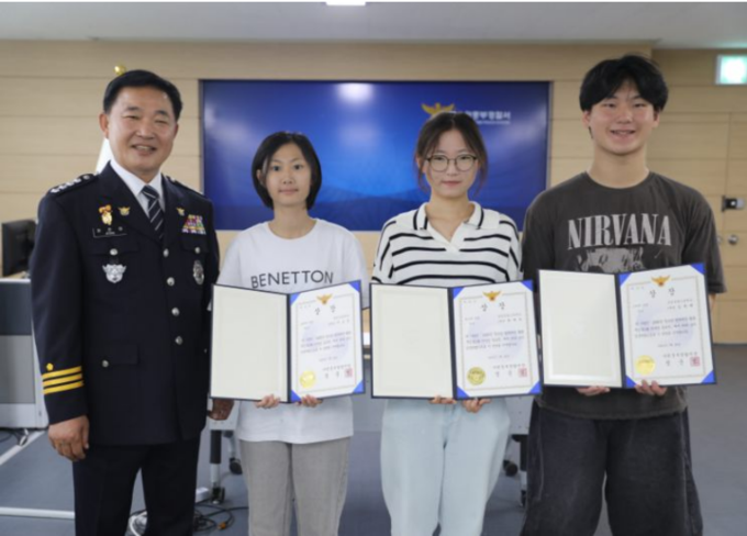 정준영 수원중부경찰서장(왼쪽)이 전자담배 무인매장 신분증 도용 금지 홍보물 공모전 시상식에서 당선작을 제출한 청소년들에게 상장을 수여했다. (사진=수원중부경찰서 제공)