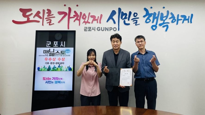 하은호 군포시장(가운데)과 관계 공무원들이 ‘2025년 전국 기초단체장 매니페스토 우수사례 경진대회’에서 기후·환경·생태 분야 ‘우수상’을 수상한 뒤 기념촬영을 하고 있다. (사진=군포시 제공)