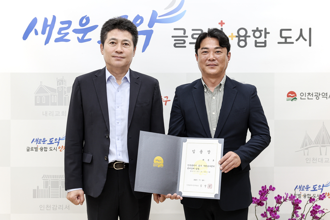 김정헌 인천 중구청장(왼쪽)이 최윤호 신임 중구자원봉사센터장에게 임용장을 수여한 뒤 기념촬영을 하고 있다. ( 사진 = 중구 제공 )