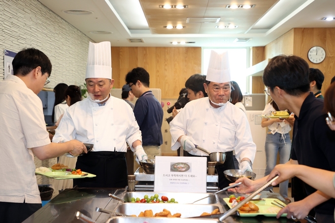 30일 이재식 수원시의회 의장(오른쪽 2번째부터), 김정렬 수원시의회 부의장이 직원들에게 삼계탕을 배식하고 있다. (사진=수원시의회 제공)