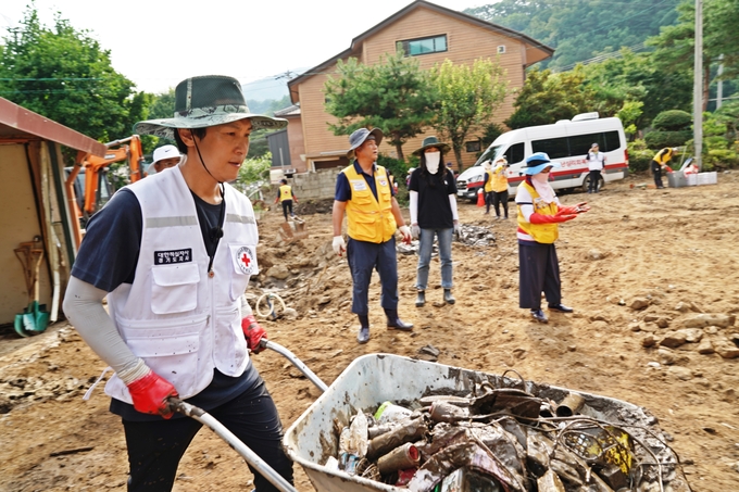 30일 가평군 홍보대사를 맡고 있는 가수 김동완 씨와 대한적십자사 경기도지사 봉사원들이 수해복구 활동을 펼치고 있다. (사진=대한적십자사 경기도지사 제공)