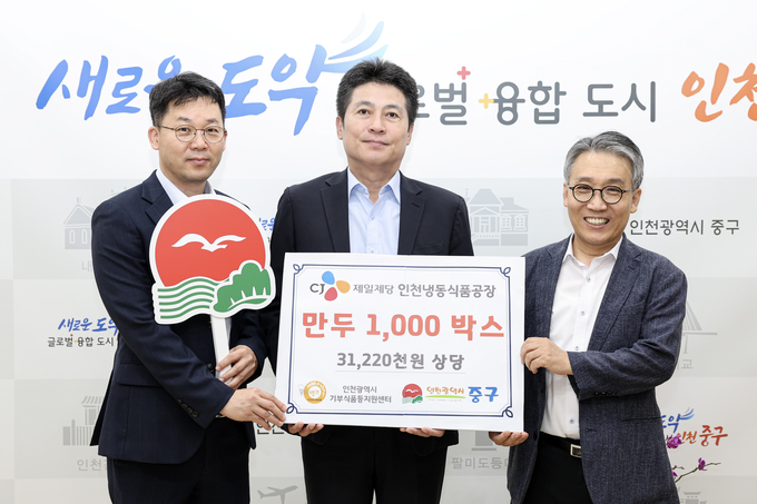 전은영 CJ제일제당 인천냉동식품공장장(왼쪽)이 김정헌 중구청장(가운데)에게 만두 1000박스를 전달하고 기념촬영을 하고 있다. ( 사진 = 중구 제공 )