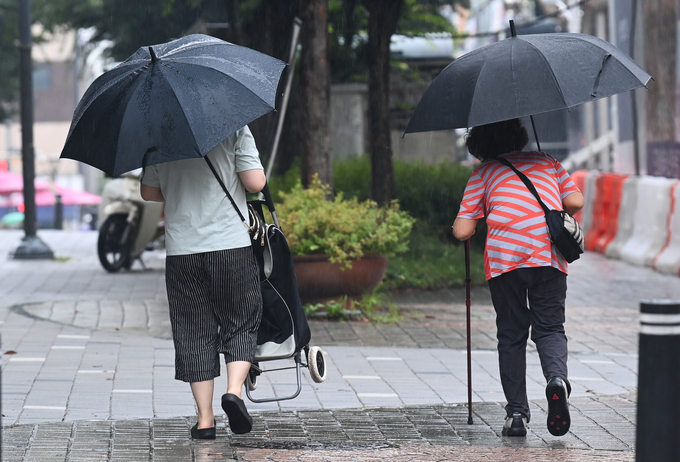  지난달 16일 용인시 기흥구에서 시민들이 우산을 쓰고 이동하고 있다. (사진=옥지훈 기자)