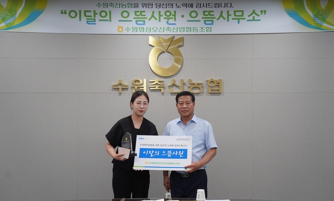 4일 이달의 으뜸사원으로 선정된 이유경 계장(왼쪽)과 장주익 수원축협 조합장이 함께하고 있다. (사진=수원축산농협 제공)