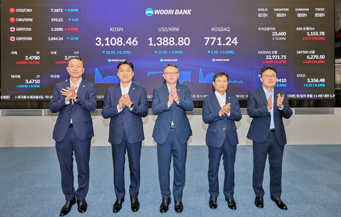 우리은행 회현동 본점 자금시장그룹 딜링룸 전광판 점등식에 (왼쪽부터) 이정섭 브랜드홍보그룹장, 박형우 자금시장그룹장, 정진완 은행장(가운데), 양현근 상임감사위원, 한세룡 업무지원그룹장이 참석해 기념촬영을 하고 있다. (사진=우리은행 제공)