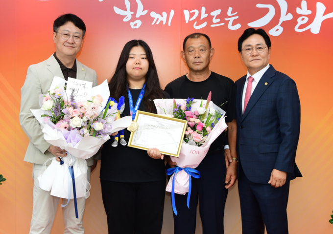 박용철 강화군수가 양궁 단체전에서 세계신기록으로 금메달을 딴 김수연 선수를 구청에 초청해 함께 기념촬영을 하고 있다. ( 사진 = 강화군 제공 )