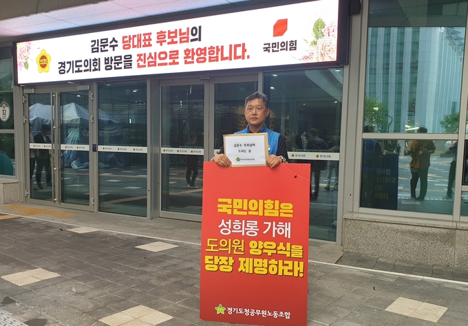 이용구 경기도청공무원 노동조합 의회사무처 지부장이 6일 경기도의회 앞에서 ‘국민의힘은 성희롱 가해 도의원 양우식을 당장 제명하라!’고 적힌 피켓을 들고 있다. (사진=나규항 기자)